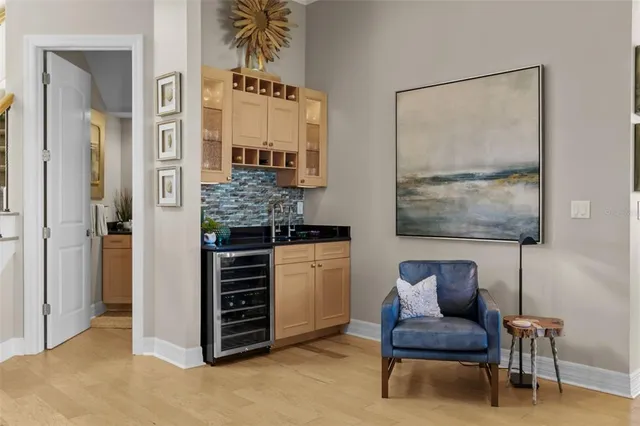 a living room with furniture kitchen view and a large window