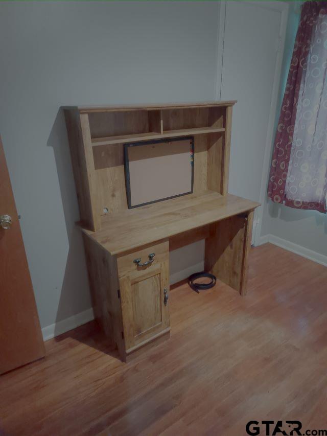 584 County Road 302 Carthage, TX 75633 - Photo 14 of 27 a room with a desk and wooden floor