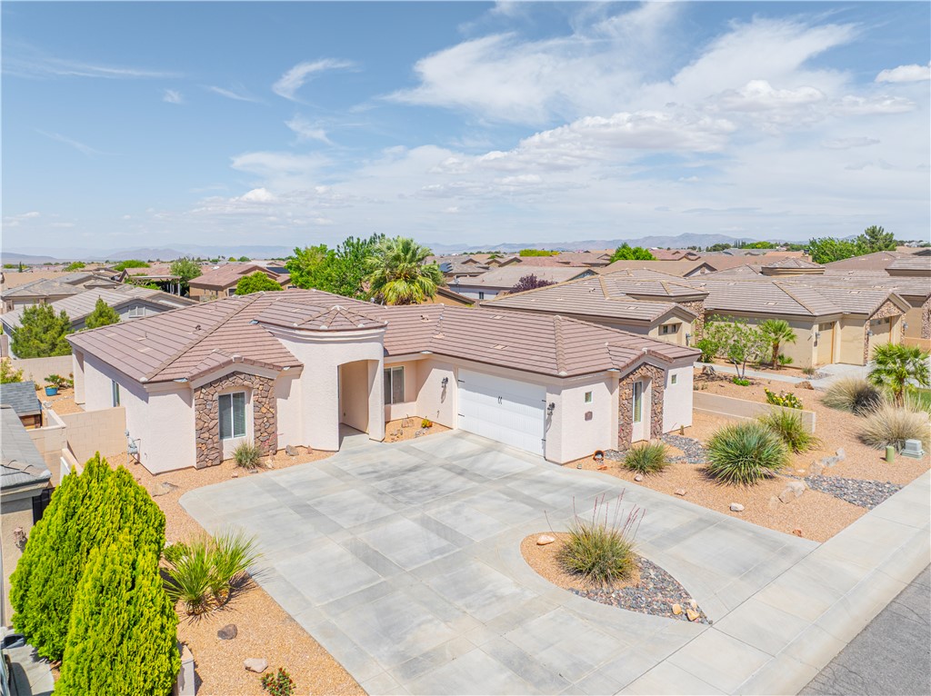 3315 Rainbow Mine Road Kingman, AZ 86401 - Photo 3 of 54 This property features a terracotta tile roof, a light-colored stucco exterior with stone accents, and an attached garage