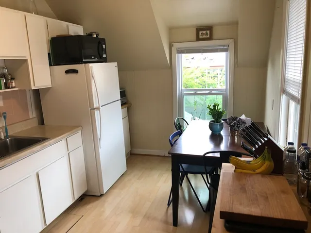 a kitchen with stainless steel appliances white cabinets and wooden floor