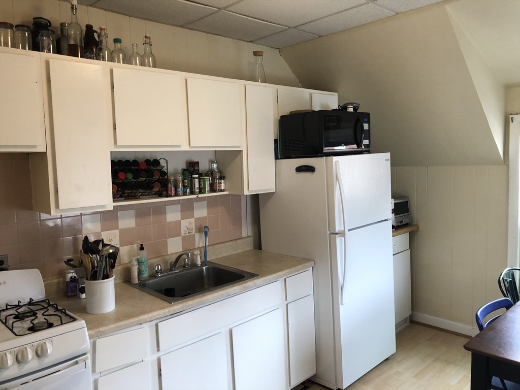 270-272 Sidney Street Cambridge, MA 02139 - Photo 20 of 24 a kitchen with stainless steel appliances a refrigerator and a stove top oven