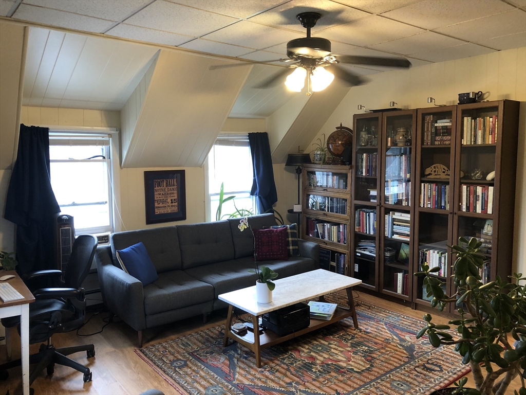 270-272 Sidney Street Cambridge, MA 02139 - Photo 22 of 24 a living room with furniture a bookshelf and a window