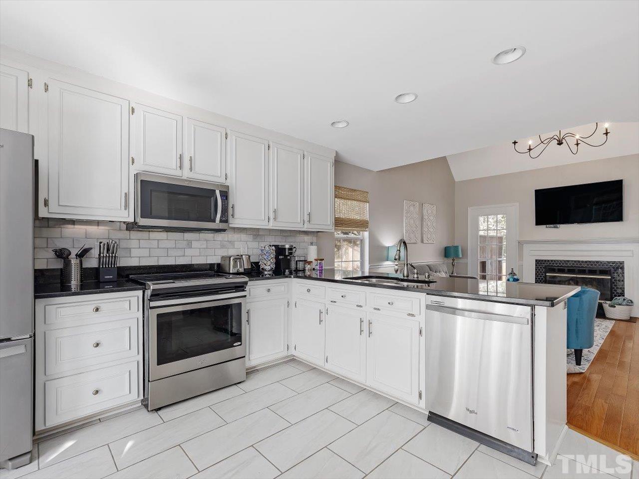4612 Timberhurst Drive Raleigh, NC 27612 - Photo 5 of 35 a kitchen with granite countertop white cabinets and white appliances