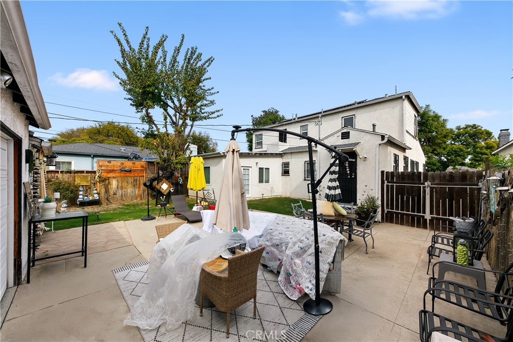 3907 Edgehill Drive Leimert Park, CA 90008 - Photo 35 of 38 a view of a patio with dining table and chairs with a small yard and plants