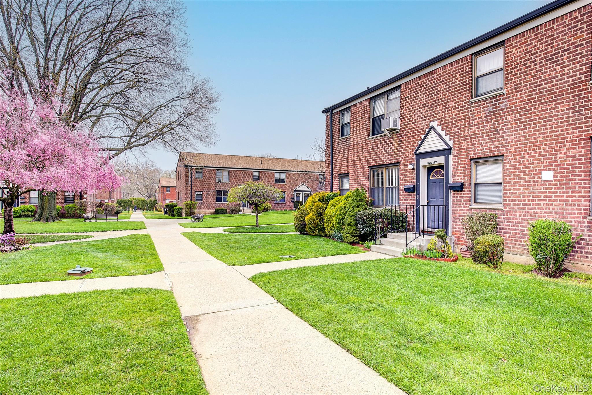 a view of a big building with a big yard and large trees