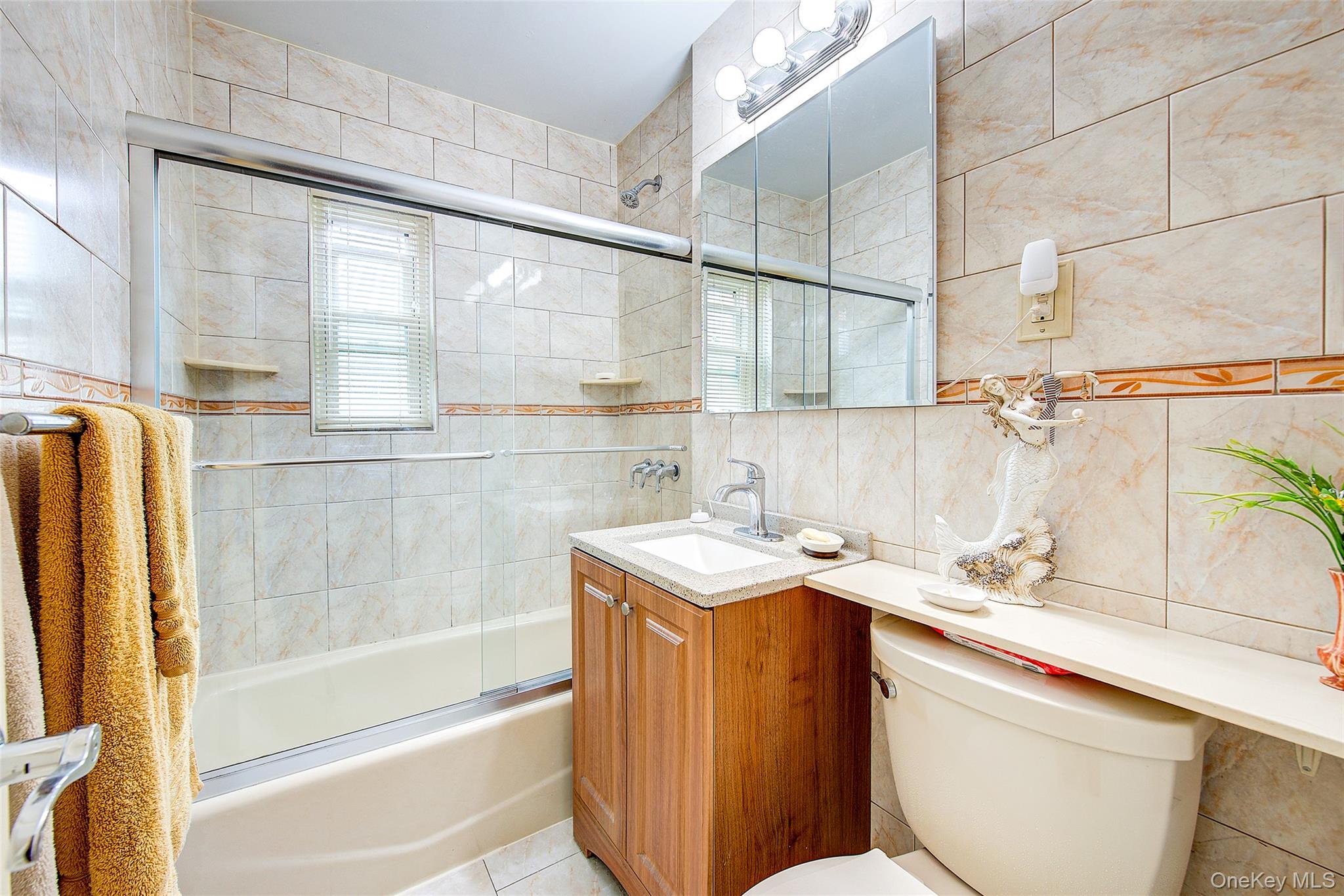196-57 69th Avenue, Unit 1 Queens, NY 11365 - Photo 16 of 18 a bathroom with a sink a toilet and a bathtub