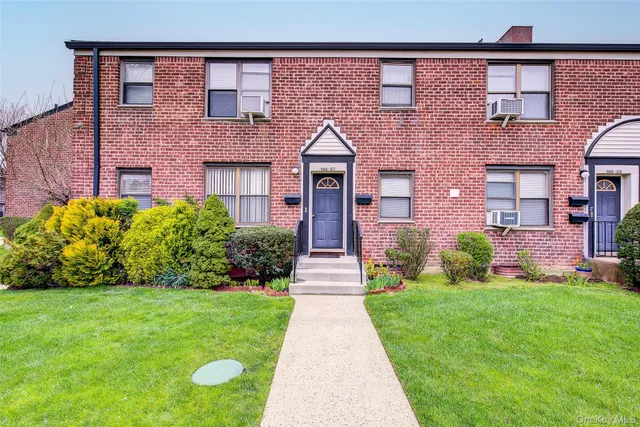 front view of a brick house with a yard