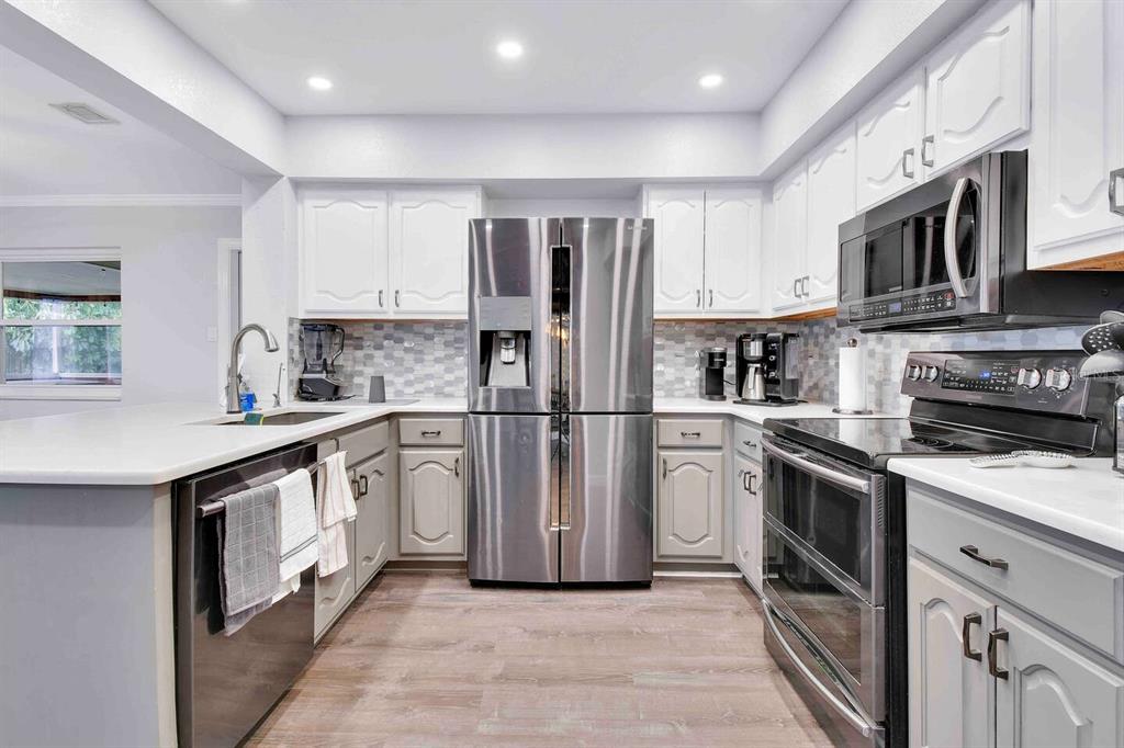 863 Bay Breeze Terrace Largo, FL 33770 - Photo 12 of 19 a kitchen with stainless steel appliances granite countertop a refrigerator sink and stove
