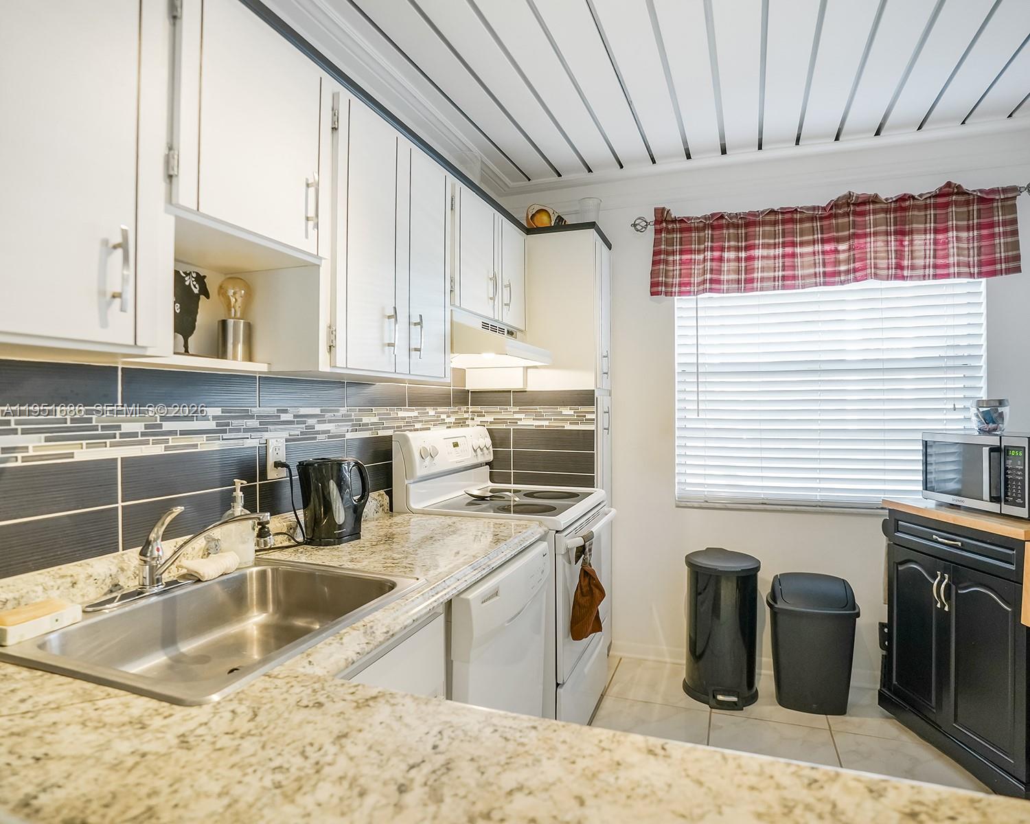 3531 Inverrary Drive, Unit 107 Lauderhill, FL 33319 - Photo 11 of 34 a kitchen with stainless steel appliances granite countertop a sink stove and cabinets