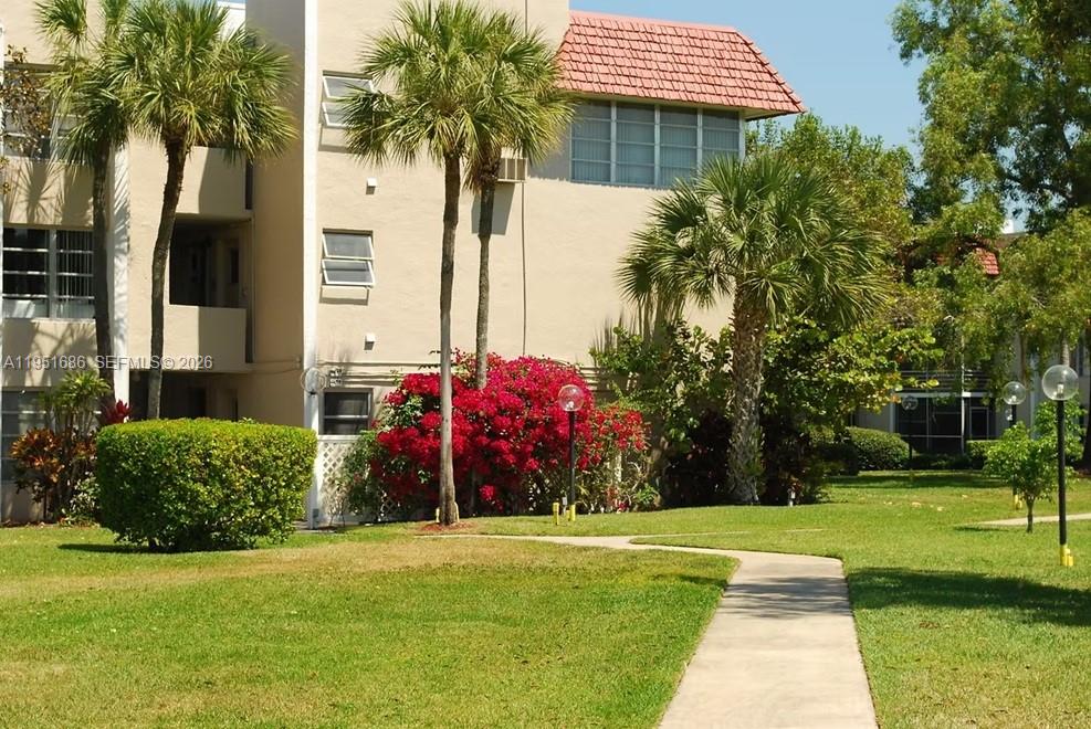 3531 Inverrary Drive, Unit 107 Lauderhill, FL 33319 - Photo 28 of 34 a front view of a house with a garden and trees