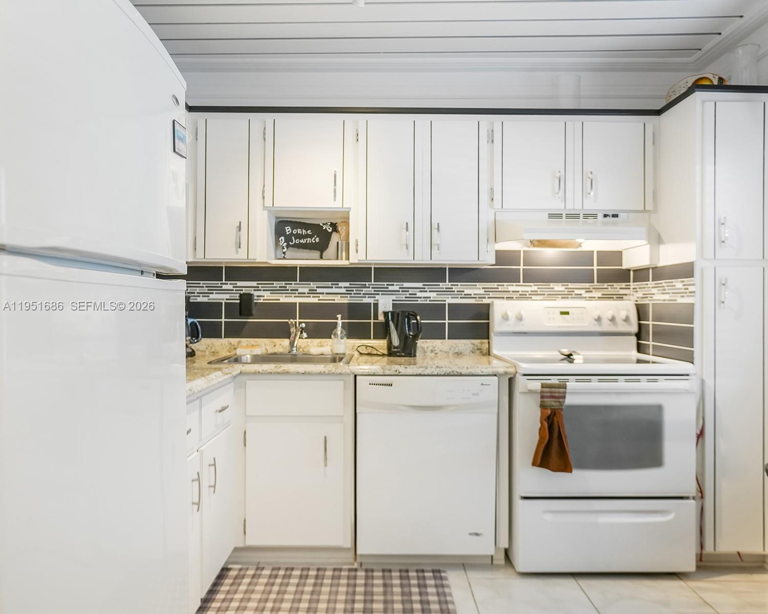 3531 Inverrary Drive, Unit 107 Lauderhill, FL 33319 - Photo 9 of 34 a kitchen with a stove a sink and a microwave