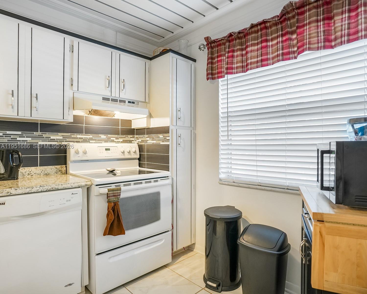 3531 Inverrary Drive, Unit 107 Lauderhill, FL 33319 - Photo 10 of 34 a kitchen with a stove and a refrigerator