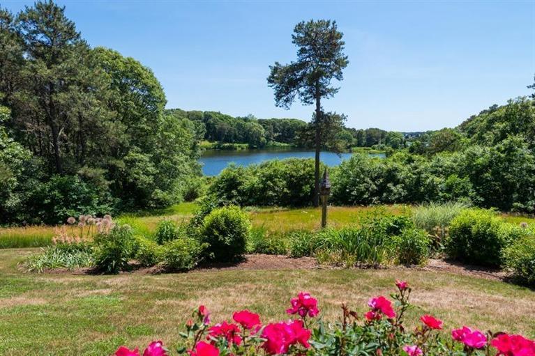 185 Ice Valley Road Osterville, MA 02655 - Photo 18 of 22 a view of a garden with a lot of flower plants and wooden fence