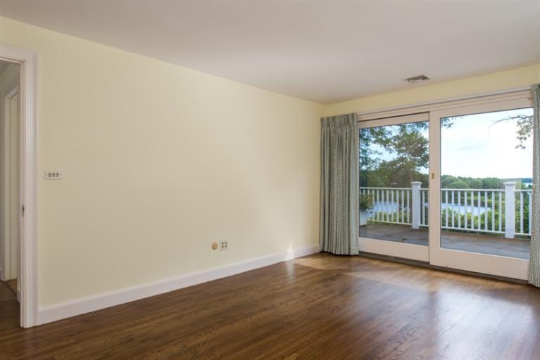185 Ice Valley Road Osterville, MA 02655 - Photo 9 of 22 an empty room with wooden floor and windows
