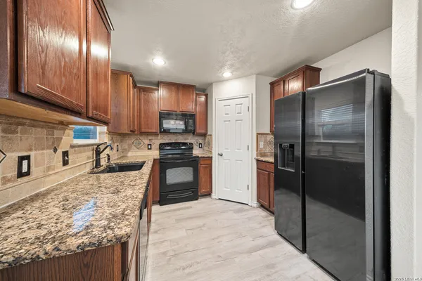 a kitchen with granite countertop stainless steel appliances and a counter top space