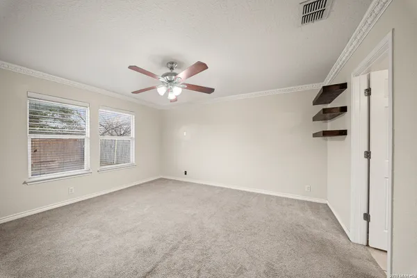an empty room with windows and fan