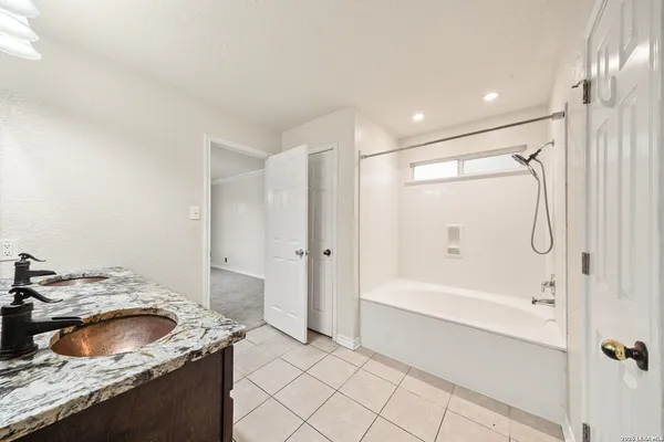 a bathroom with a granite countertop sink a toilet and bathtub