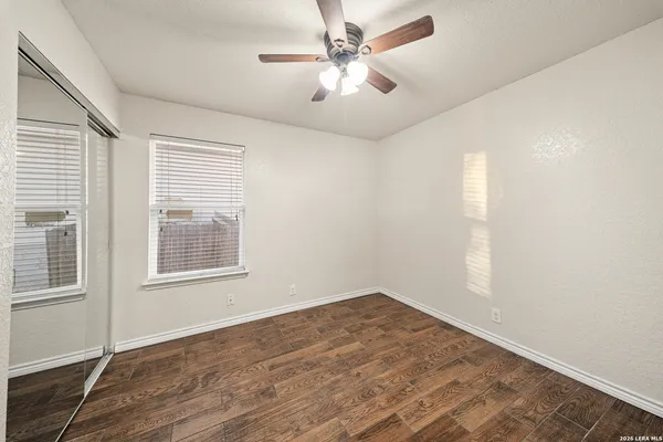 an empty room with wooden floor and windows