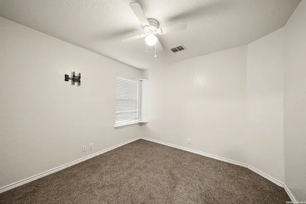 an empty room with a window and a ceiling fan
