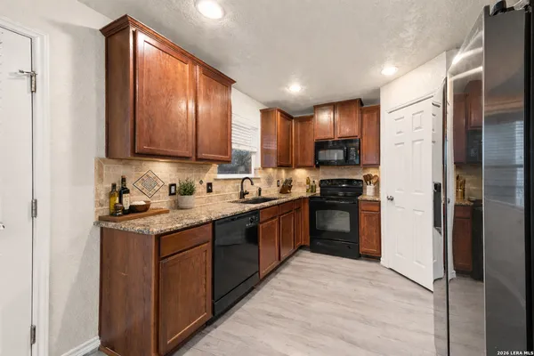a kitchen with stainless steel appliances granite countertop a stove refrigerator sink and cabinets