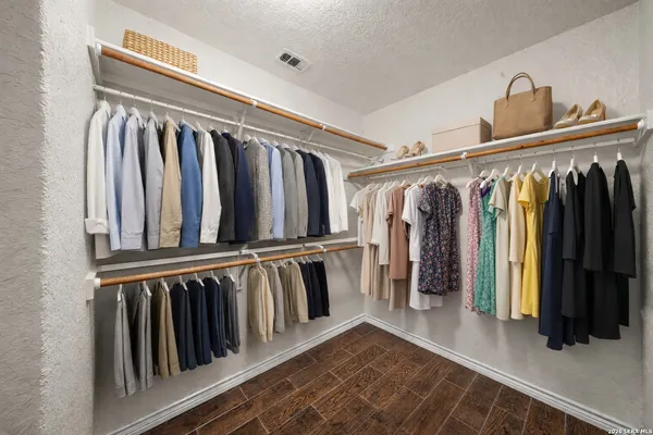 a view of walk in closet with clothes and shoes