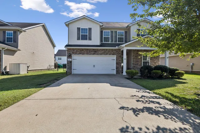 a front view of a house with a garden and trees