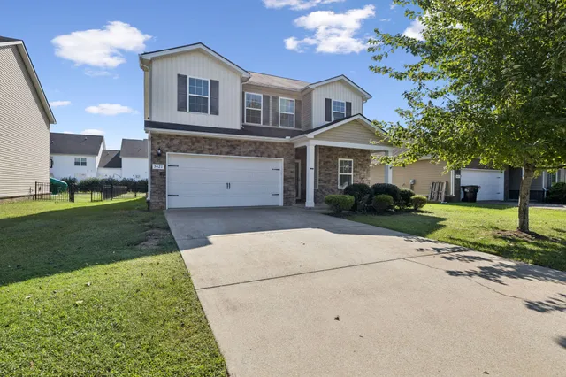 a front view of a house with a garden and trees