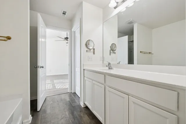 a view of an empty room with a window and a kitchen