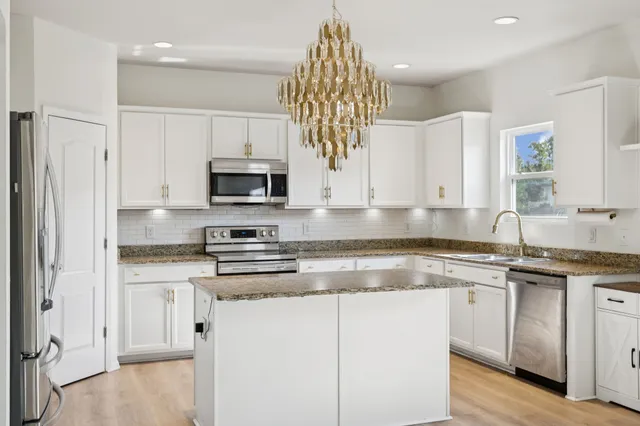 a kitchen with stainless steel appliances a refrigerator sink and cabinets