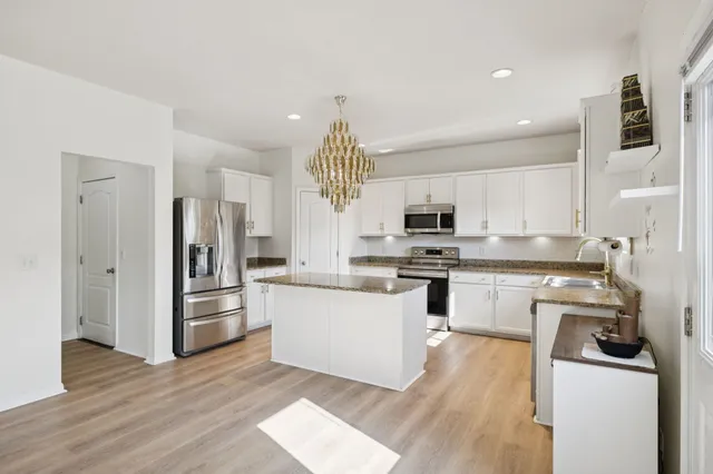 a kitchen with granite countertop a refrigerator stove and microwave
