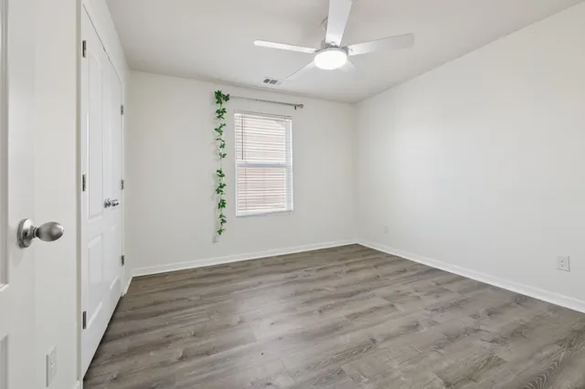 a view of an empty room with wooden floor