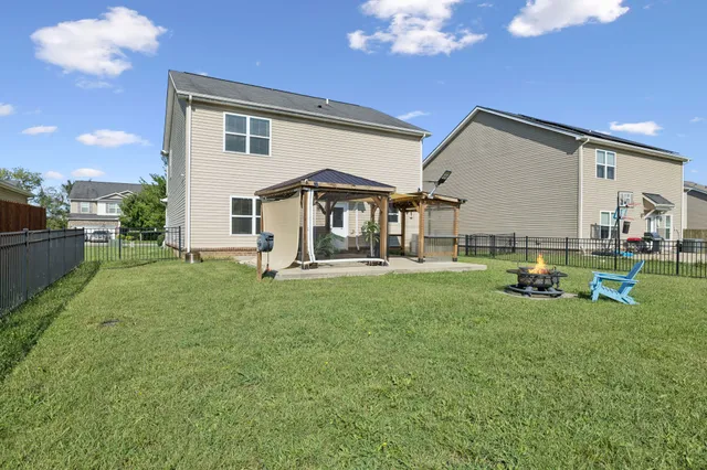 a front view of a house with a garden and lake view
