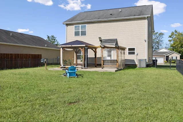 a view of a house with backyard and a tree