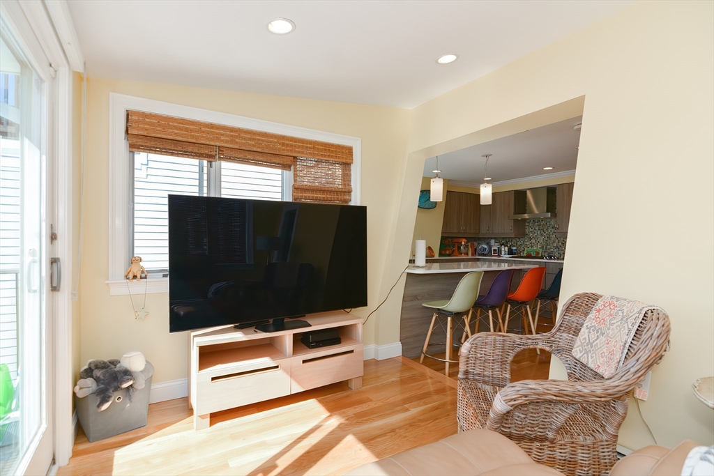 269 Webster Street, Unit 4 Boston, MA 02128 - Photo 16 of 36 a living room with furniture a flat screen tv and kitchen view