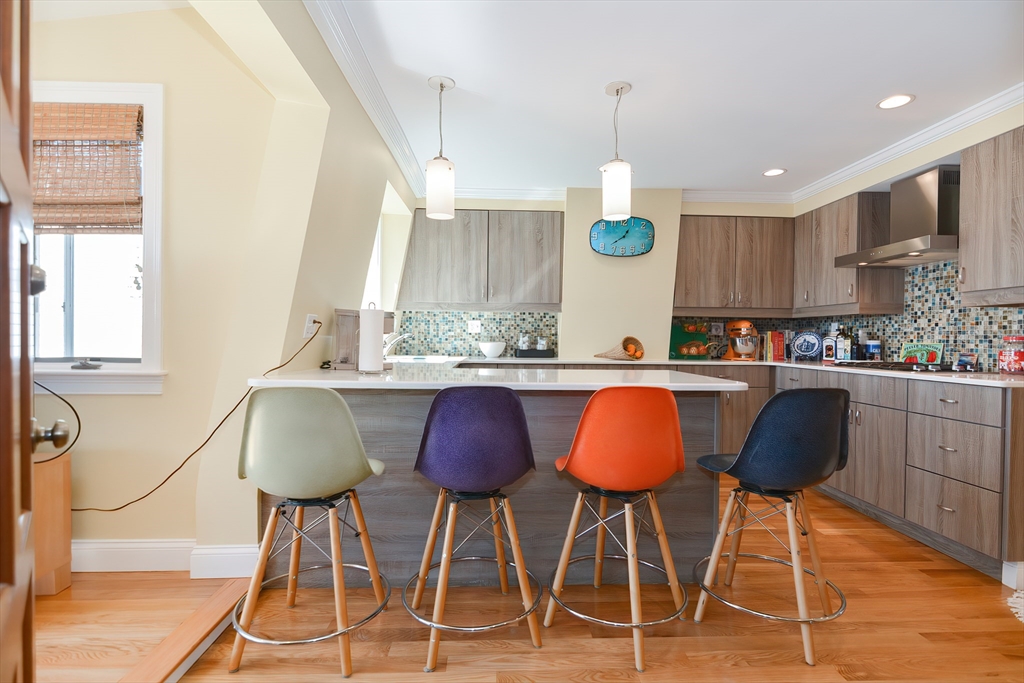269 Webster Street, Unit 4 Boston, MA 02128 - Photo 5 of 36 a kitchen with stainless steel appliances granite countertop a table chairs and a sink