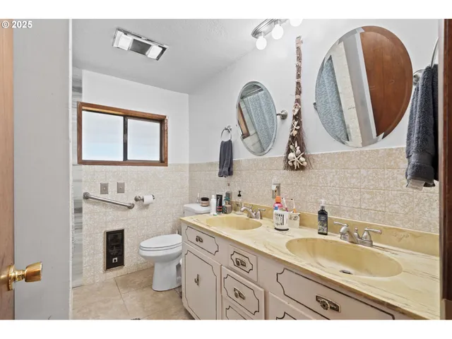a bathroom with a double vanity sink mirror and toilet