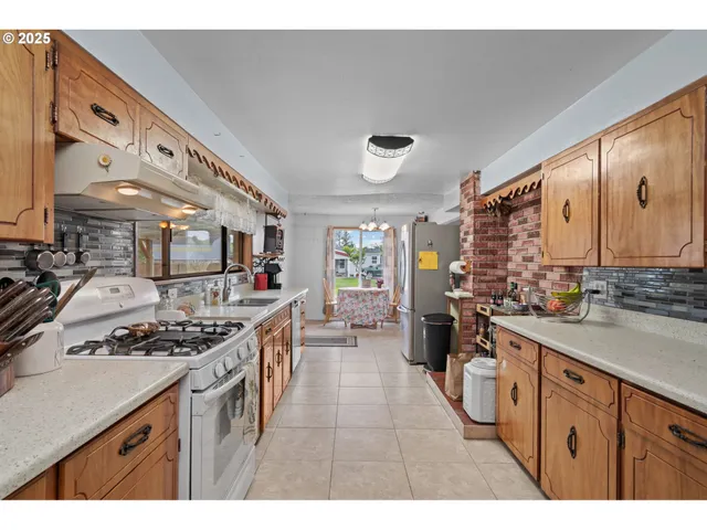 a kitchen with stainless steel appliances a stove a sink dishwasher and cabinets with wooden floor