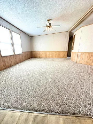 a view of a livingroom with kitchen and a window