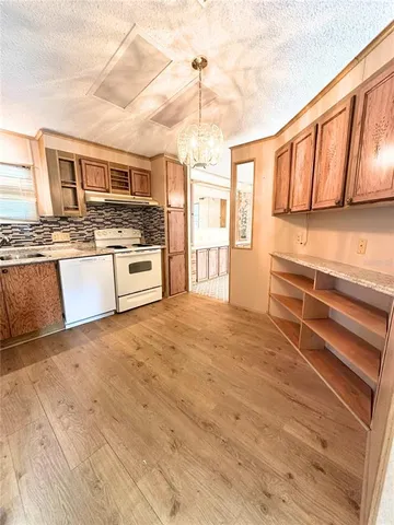 a view of a room with wooden floor and furniture
