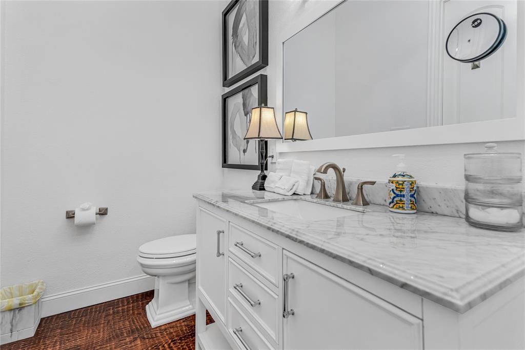 5744 Robbie Road Plano, TX 75024 - Photo 7 of 32 White vanity with a marble countertop, undermount sink, and brushed nickel faucet