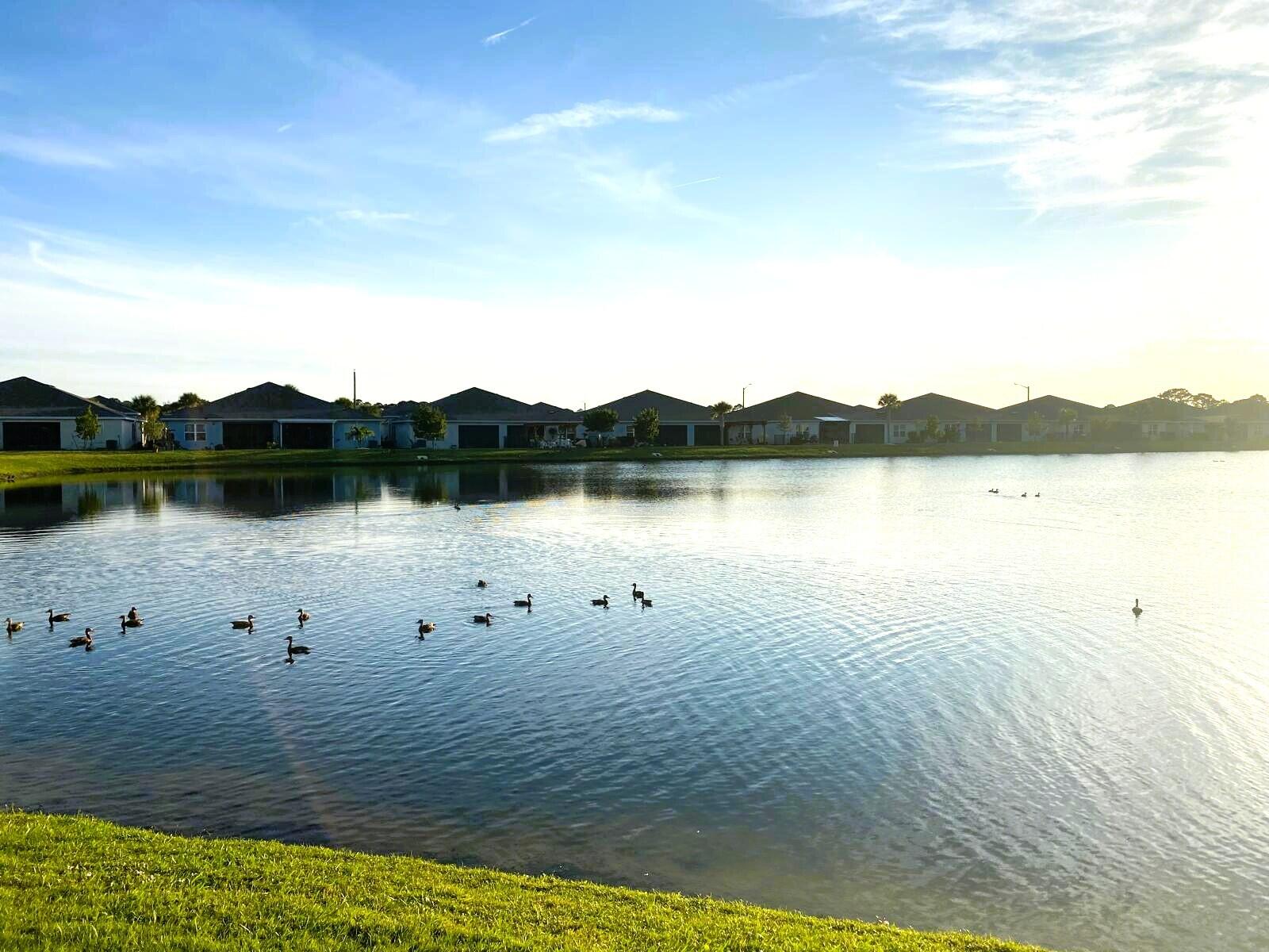 106 Pummelo Place Fort Pierce, FL 34981 - Photo 26 of 27 a view of a lake with houses in the background