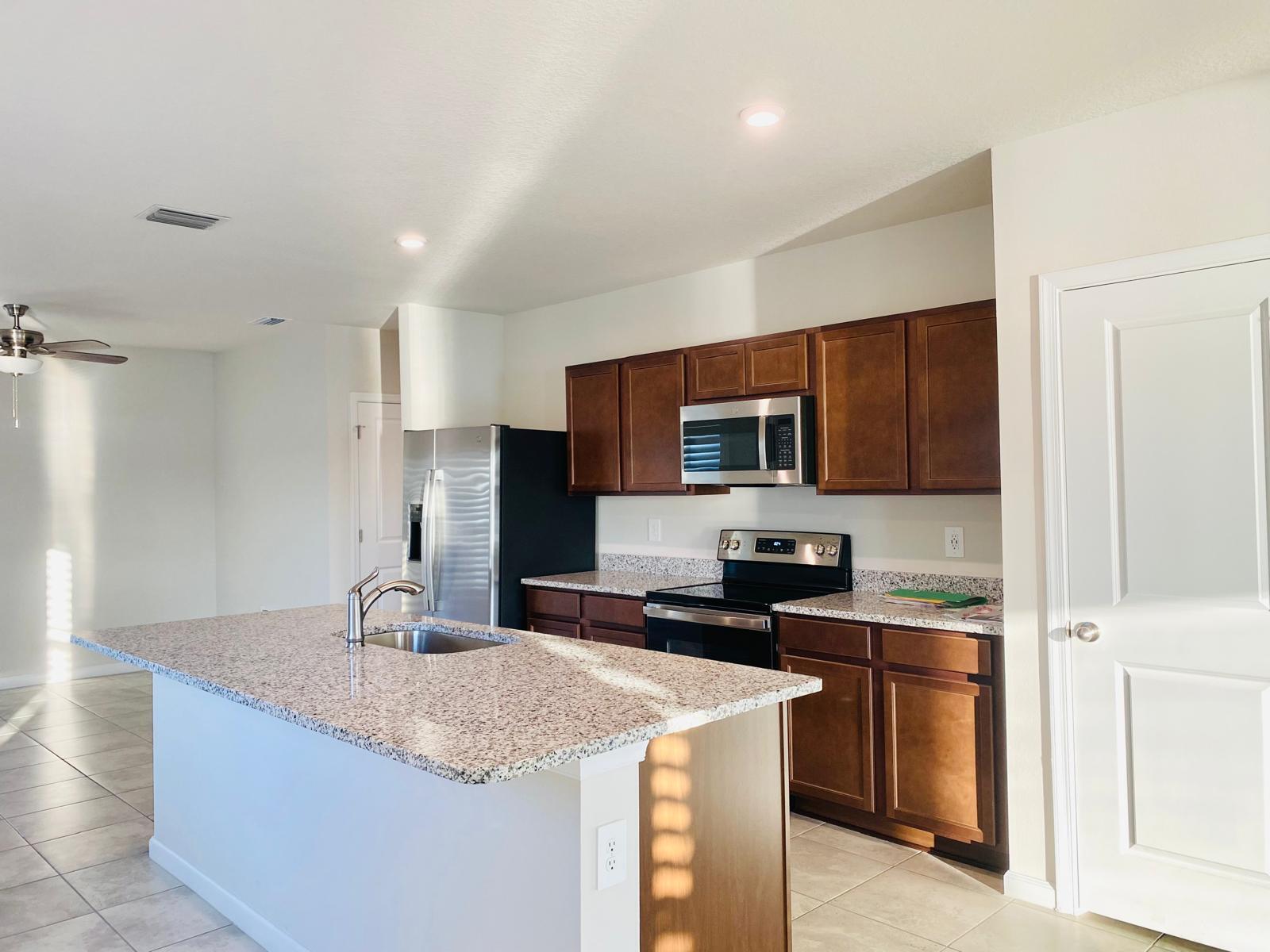 106 Pummelo Place Fort Pierce, FL 34981 - Photo 4 of 27 a kitchen with stainless steel appliances granite countertop a sink stove and refrigerator