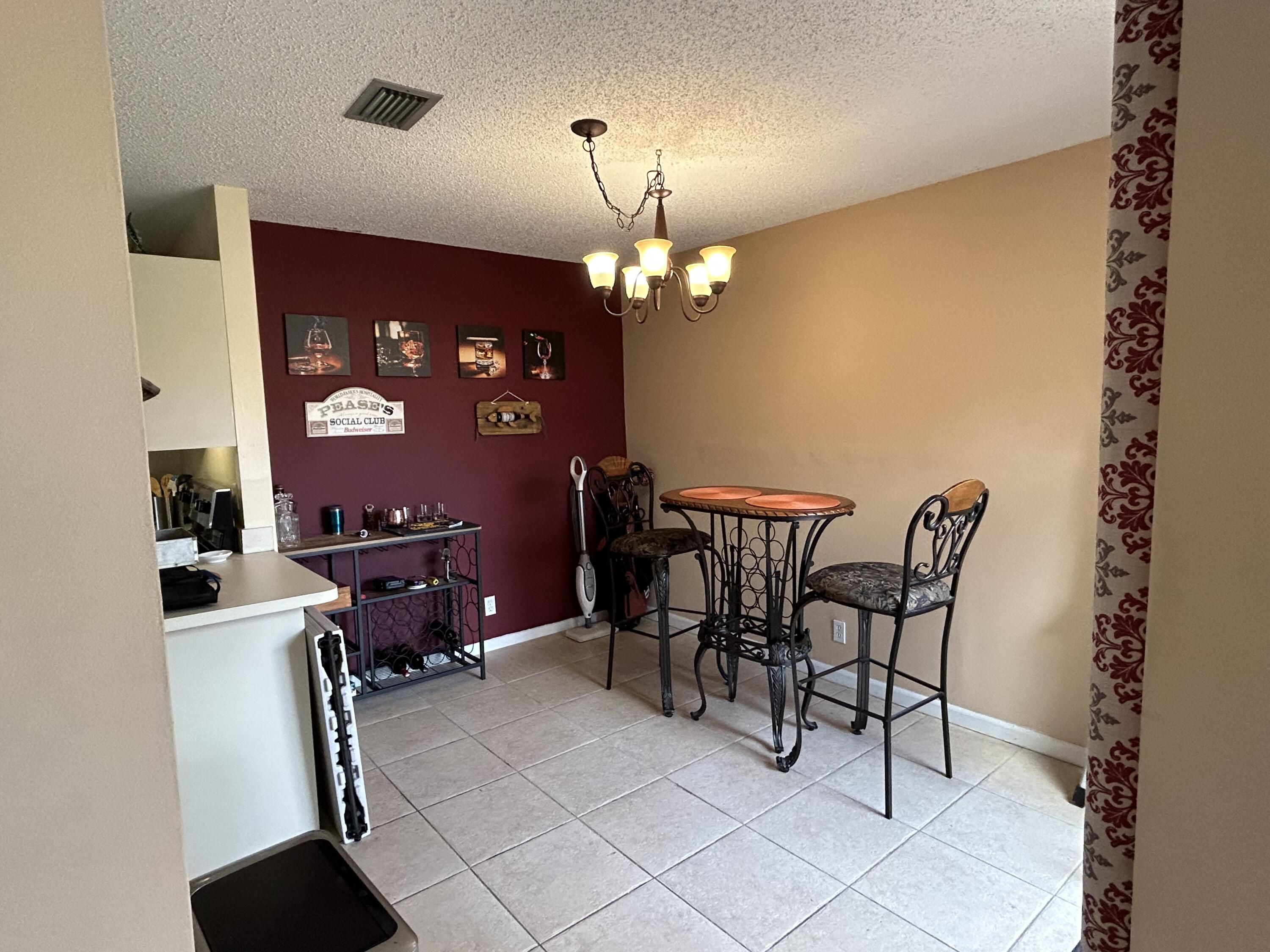 201 Meadows Drive Boynton Beach, FL 33436 - Photo 12 of 40 a view of a dining room with furniture and chandelier
