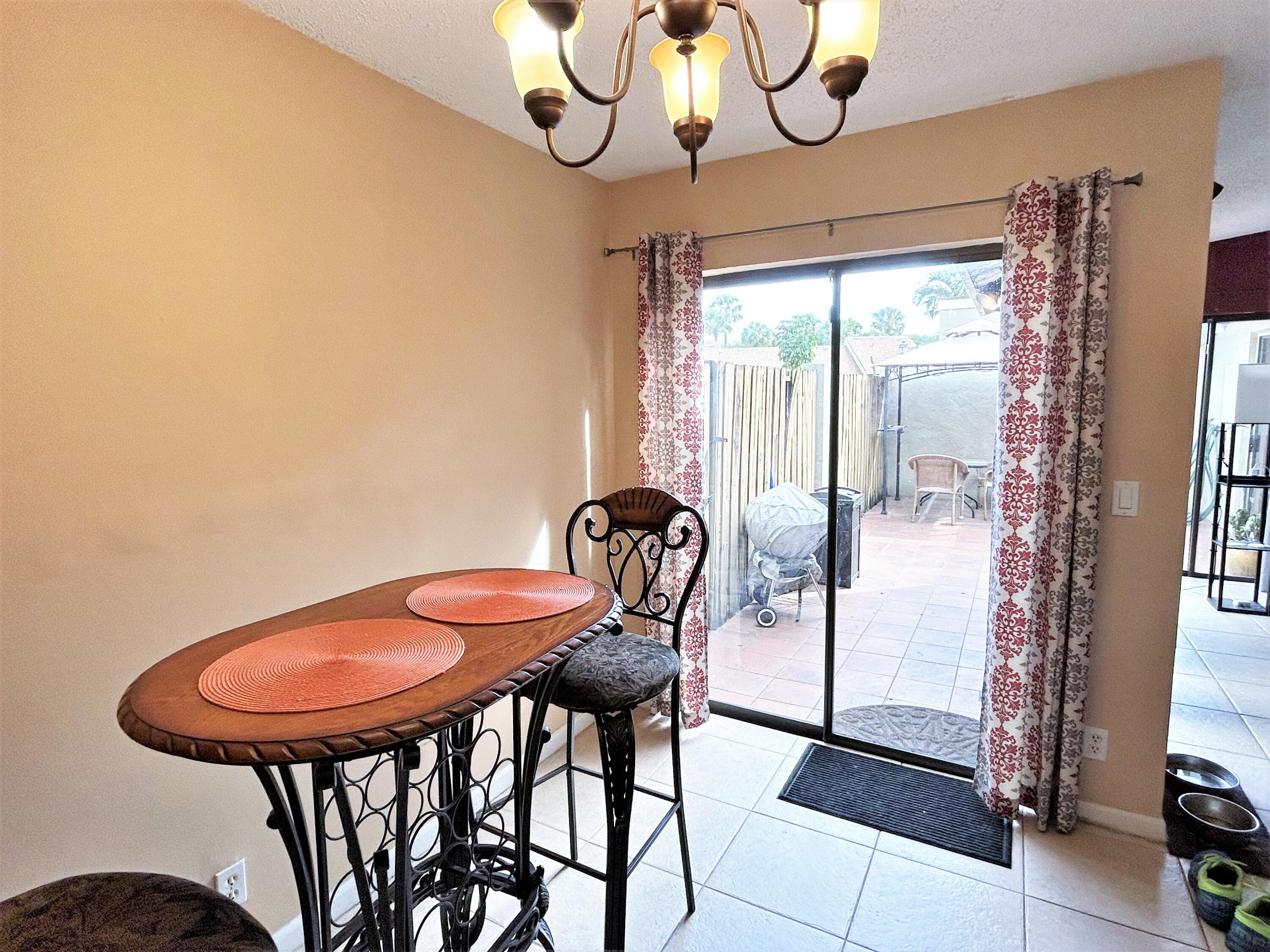 201 Meadows Drive Boynton Beach, FL 33436 - Photo 13 of 40 a view of a dining room with furniture wooden floor and a chandelier