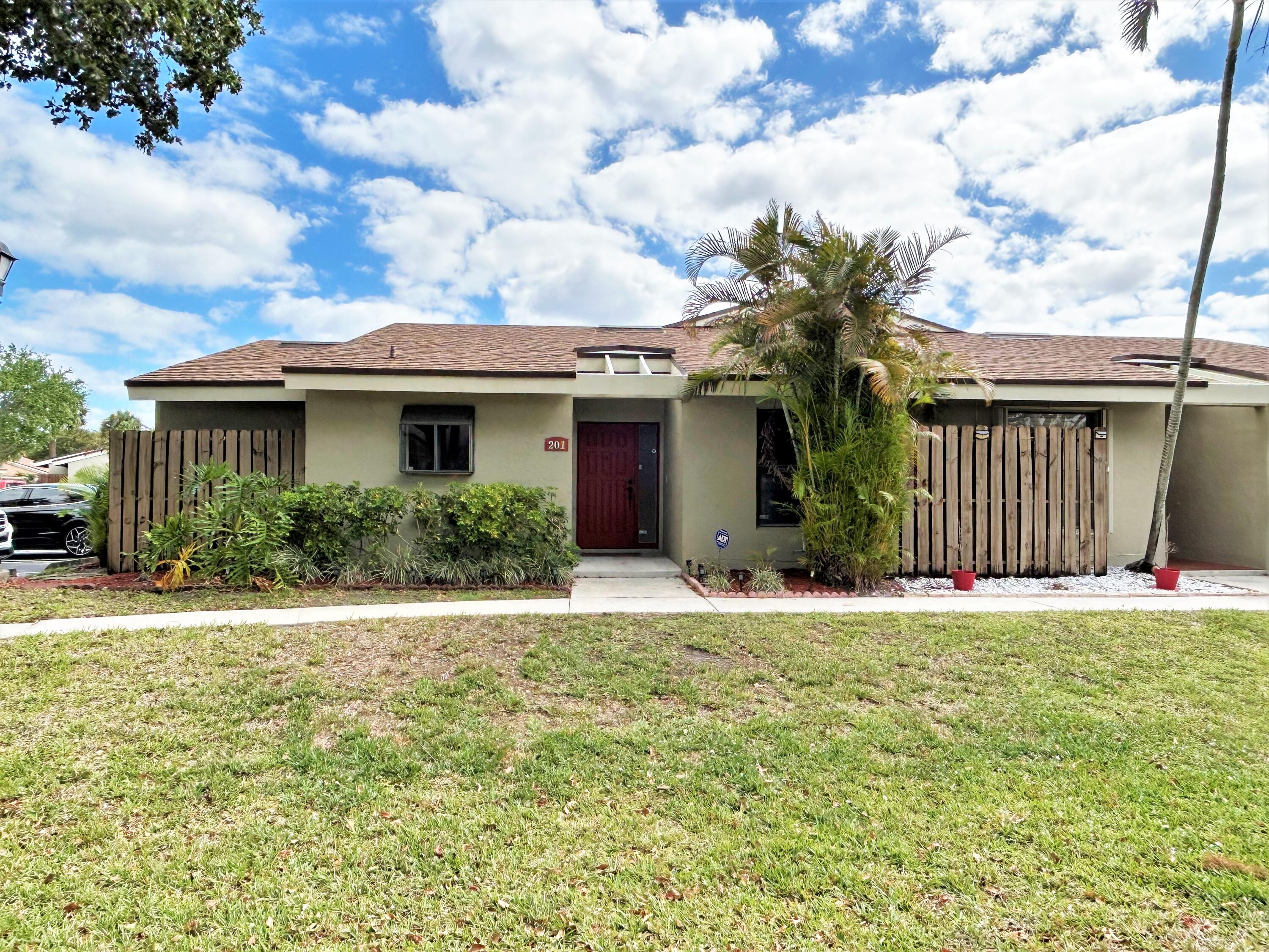 201 Meadows Drive Boynton Beach, FL 33436 - Photo 2 of 40 a front view of a house with a garden