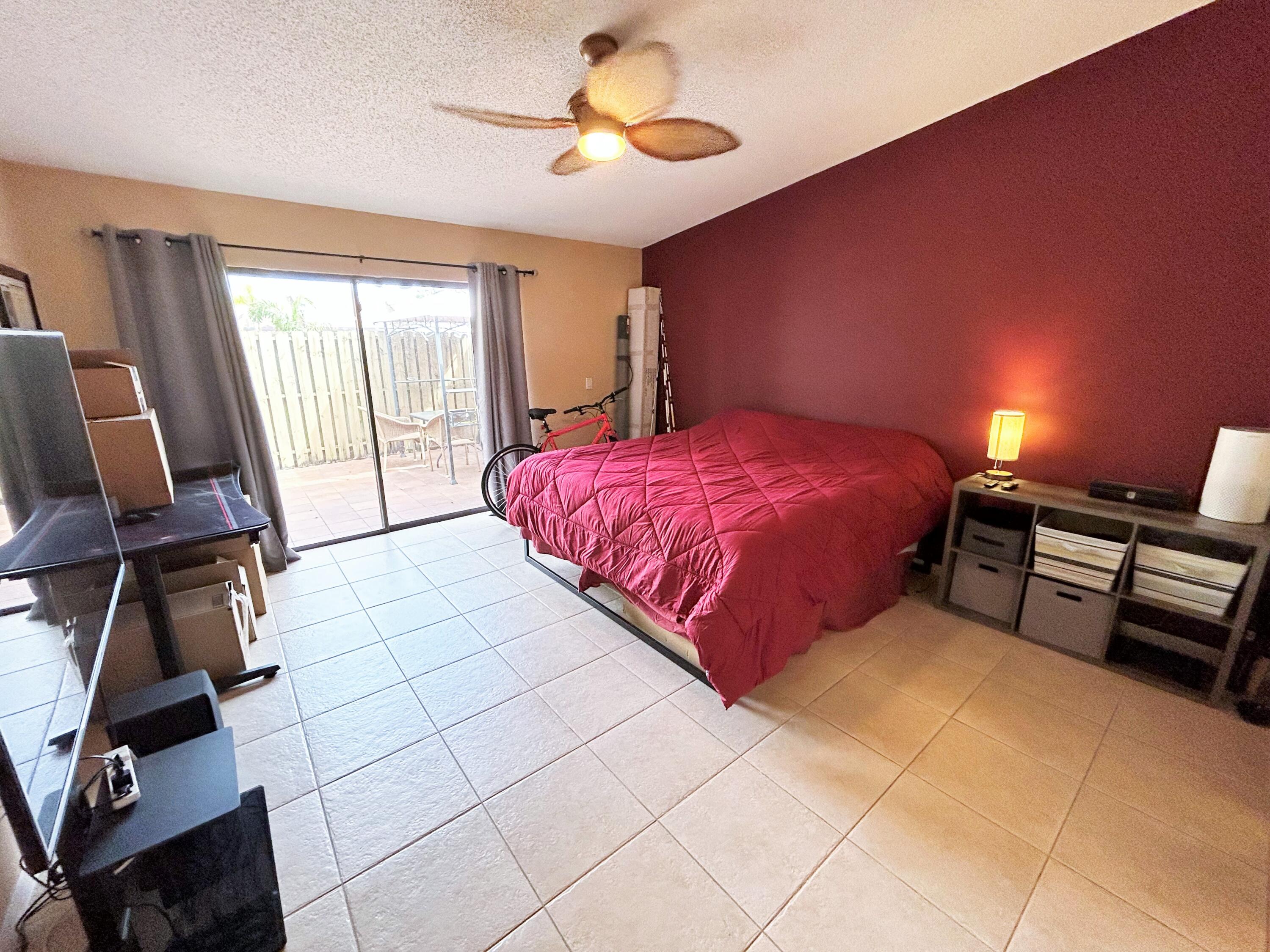 201 Meadows Drive Boynton Beach, FL 33436 - Photo 21 of 40 a spacious bedroom with a bed and a chandelier