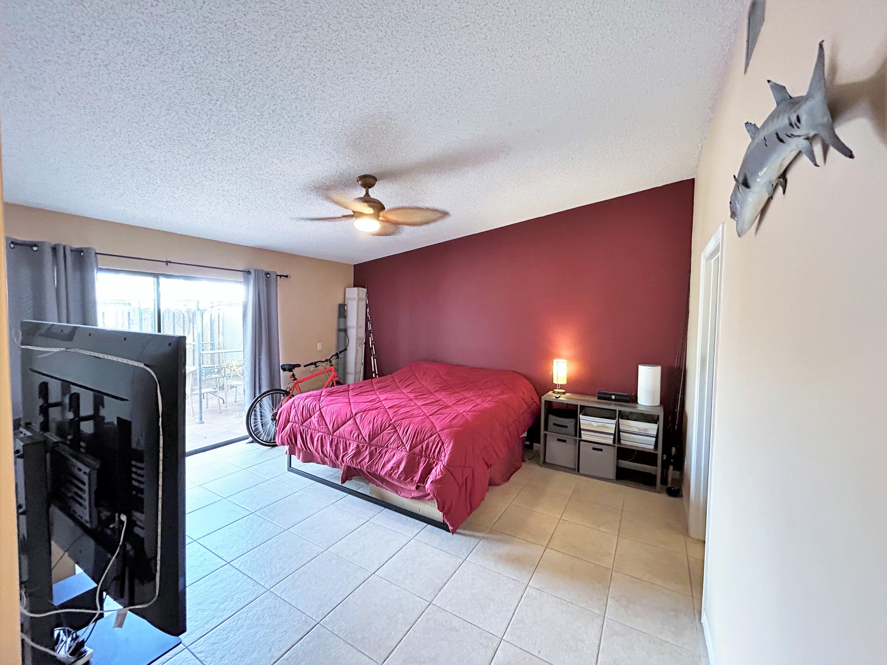 201 Meadows Drive Boynton Beach, FL 33436 - Photo 22 of 40 a spacious bedroom with a bed and a chandelier