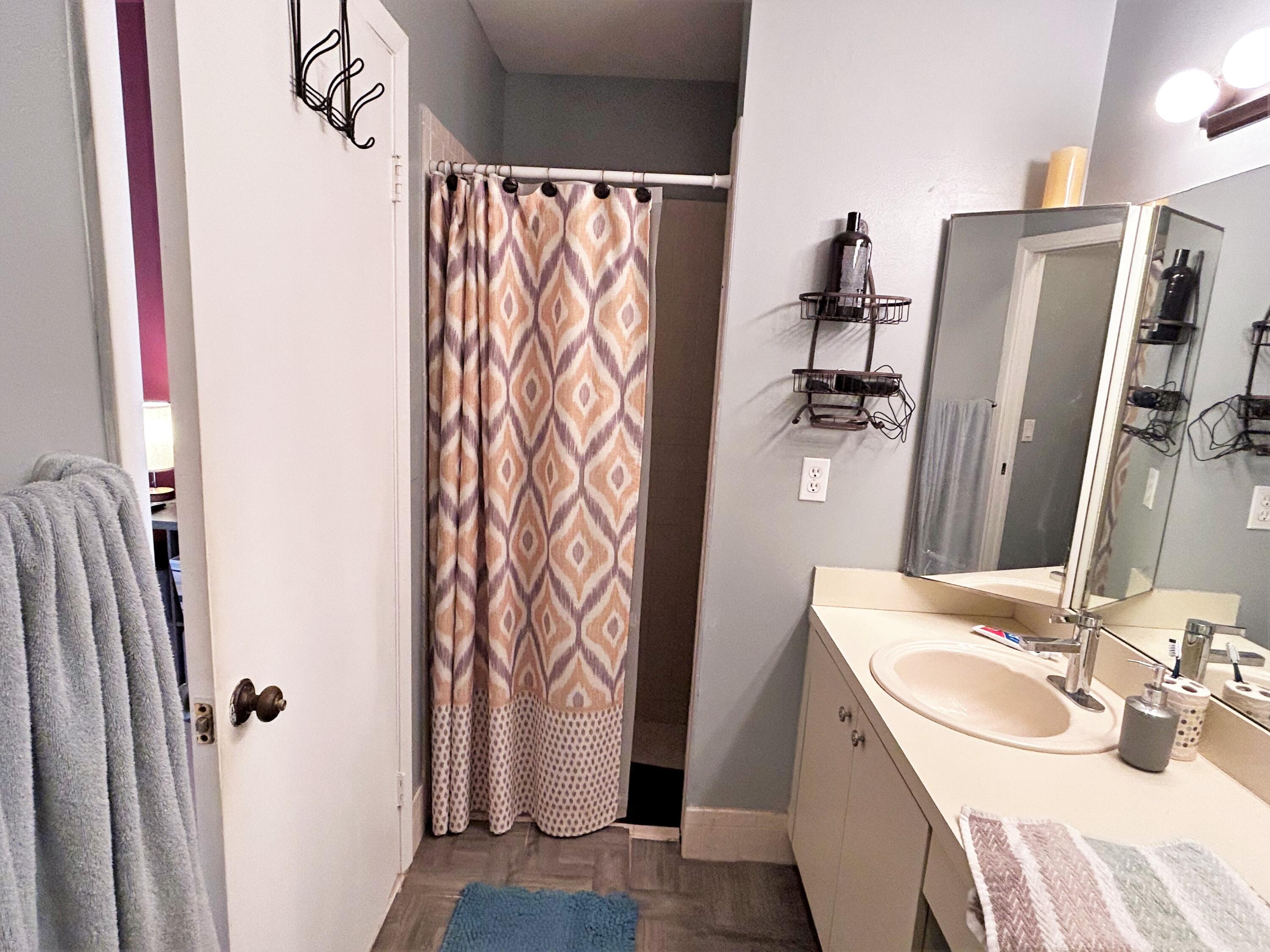 201 Meadows Drive Boynton Beach, FL 33436 - Photo 23 of 40 a bathroom with a sink a mirror and shower curtain