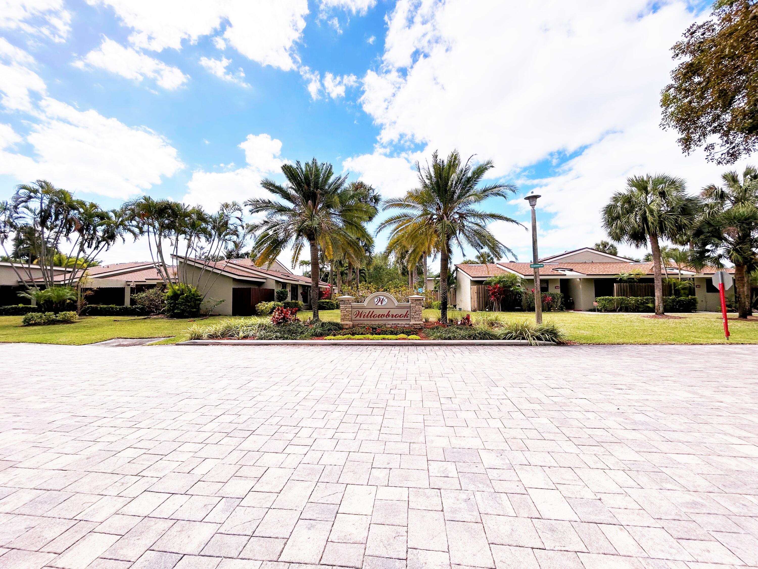 201 Meadows Drive Boynton Beach, FL 33436 - Photo 39 of 40 a front view of a house with a swimming pool and sitting area