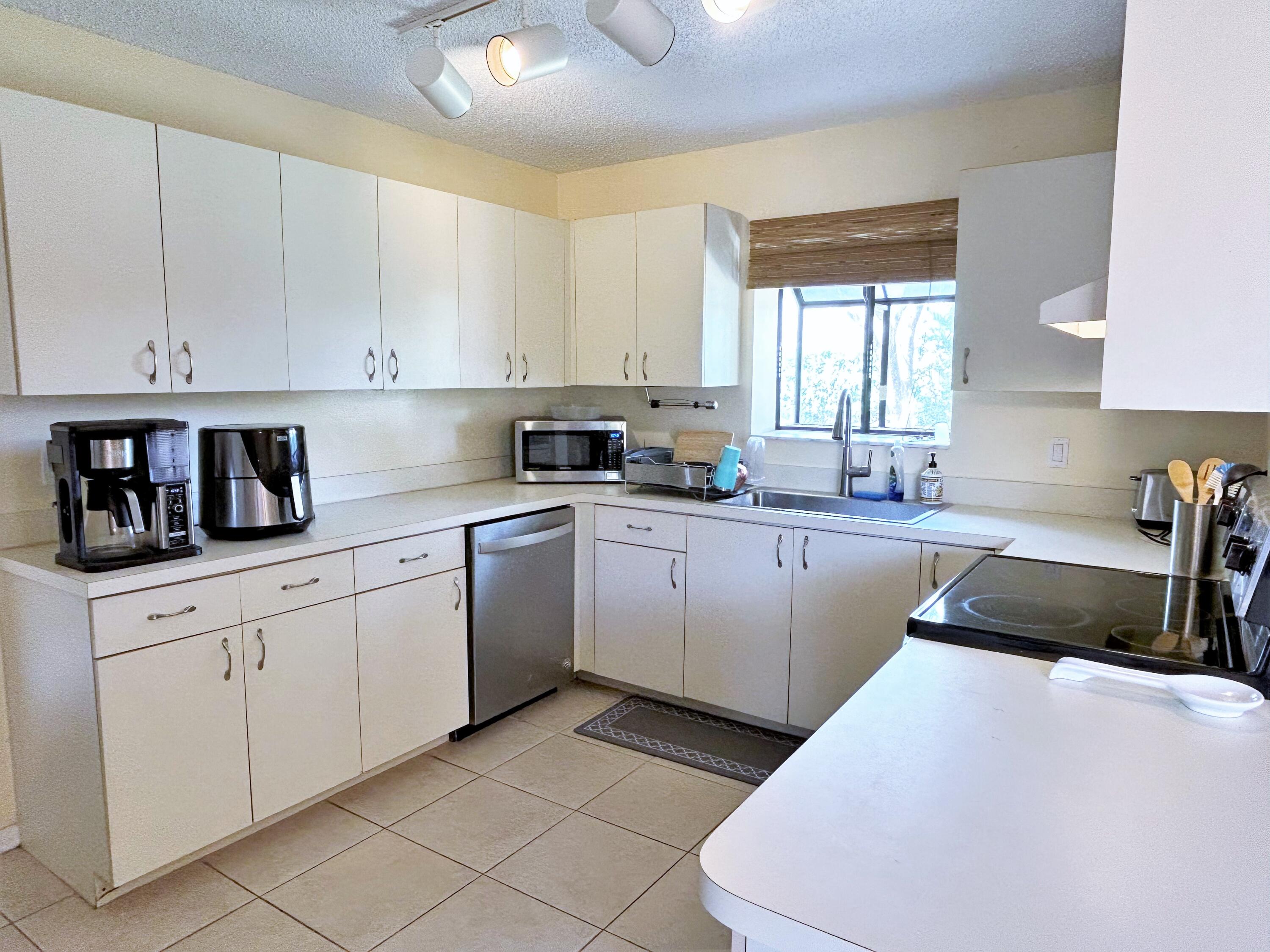 201 Meadows Drive Boynton Beach, FL 33436 - Photo 5 of 40 a kitchen with cabinets appliances a sink and a window